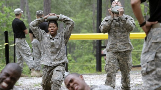 One of the 20 female soldiers, top left, among the 400 students who qualified to begin Ranger School, does lunges.