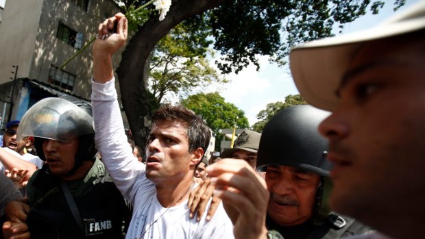 Then opposition leader Leopoldo Lopez is flanked by  National Guards after he surrendered in Caracas, Venezuela, in February 2014.