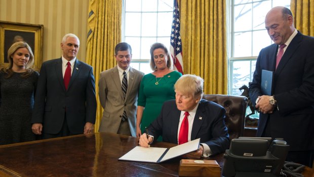 US President Donald Trump signs an executive order calling for a rewriting of major provisions of the 2010 Dodd-Frank Act.