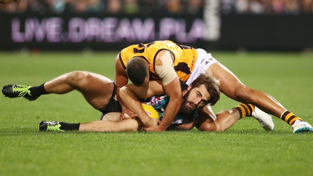The Hawks' Josh Gibson tackles Justin Westhoff during the win against Port Adelaide on Thursday night. 