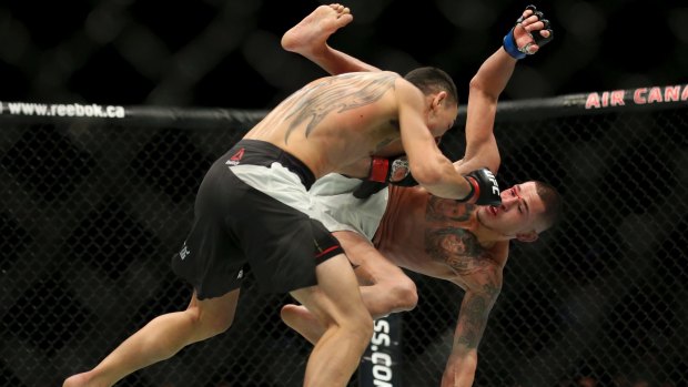 Takedown: Max Holloway, left, knocks Anthony Pettis to the mat.