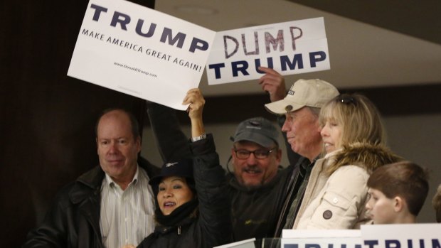 A Donald Trump supporter holds up a sign trying to block Walter Skold, who is holding a "Dump Trump" sign at a campaign stop in Portland, Maine.
