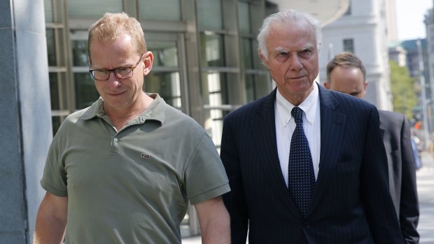 HSBC's head of foreign exchange cash trading Mark Johnson, 50, left, leaving the US District Court in Brooklyn with an attorney after posting bail on Wednesday.