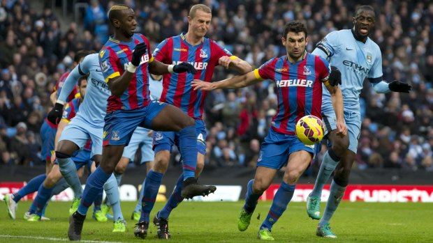 Manchester City's Yaya Toure, right, attempts to beat the Crystal Palace defence including Australia's Mile Jedinak,