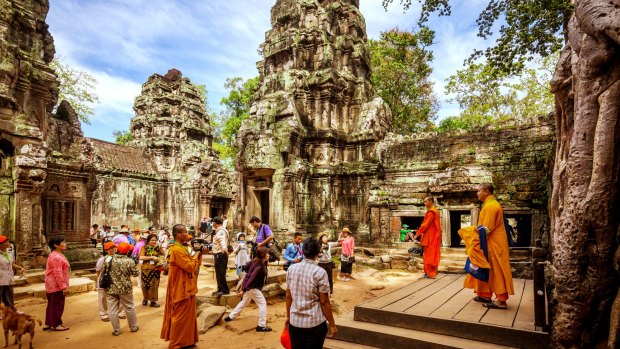 Tourists wander the historic ruins of Angkor Wat in Cambodia. 