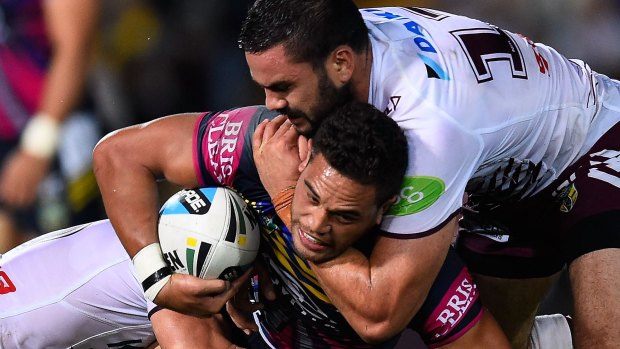 Tough going: Cowboys winger Antonio Winterstein is tackled by Manly forward Justin Horo.