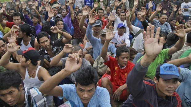 On April 3, rescued Burmese fishermen raise their hands as they are asked who among them wants to go home at the compound of Pusaka Benjina Resources fishing company in Benjina, Aru Islands, Indonesia. 