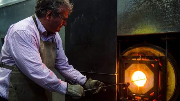 <i>Canberra Times</i> reporter Ron Cerabona under the supervision of Make Your Own instructor Nick Adams, heats what will be a glass tumbler at Canberra Glassworks. 