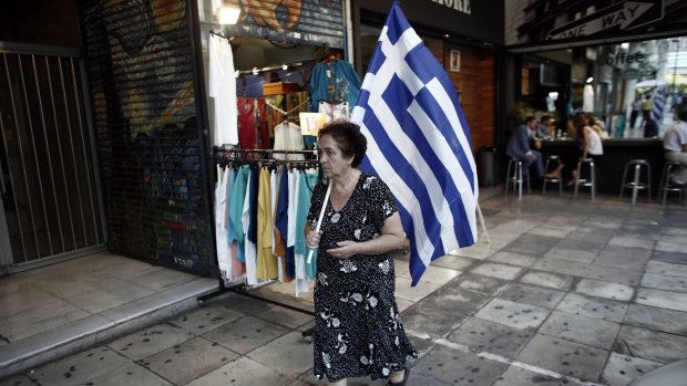 A New Democracy Party of Greece supporter carries a Greek national flag for a pre-election rally with party leader Vangelis Meimarakis. 