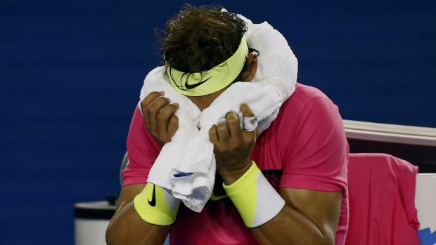 Feeling the effects: Rafael Nadal applies an ice-pack to his head.