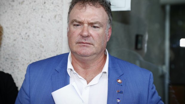 Rod Culleton, with his  Australian Senator pin on display, departs the High Court. 