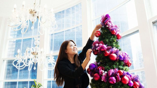 Store assistant Erica Chen puts the final touches on a Christmas tree in David Jones Market Street.
