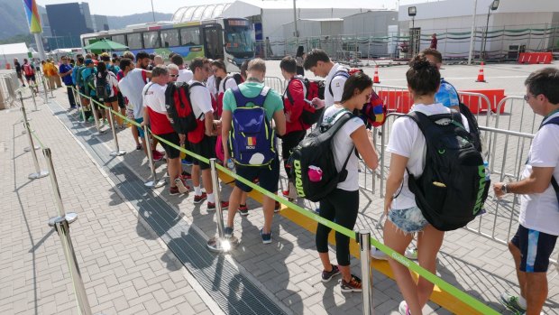 Swimmers wait for the athletes' bus after a training session.