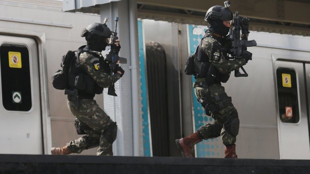Brazilian soldiers conduct a counter-terrorism drill simulating an attack at the Deodoro train station in Rio on Saturday.