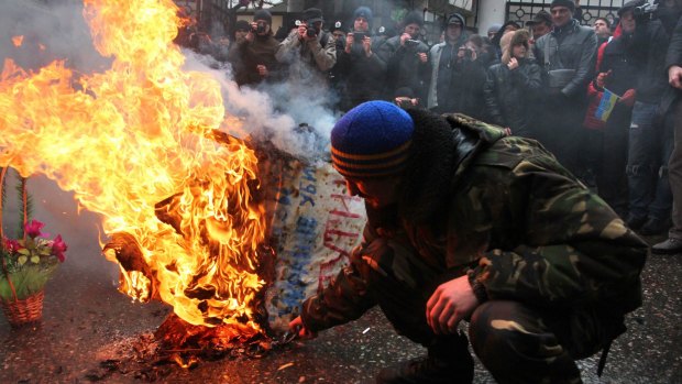 A symbolic coffin of Russian President Vladimir Putin is set aflame by protesters in Odessa.