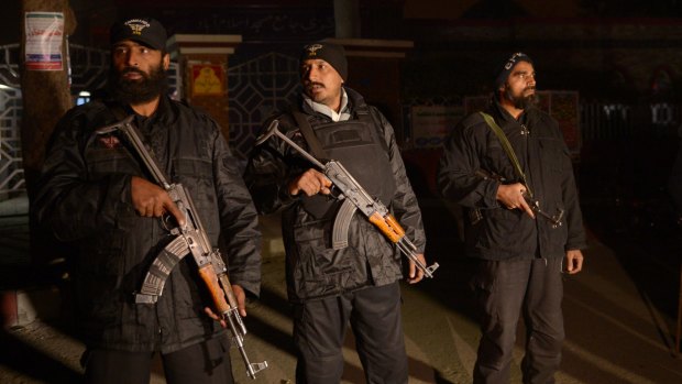 Pakistani commandos stand guard during a rally for the 140 victims of the shooting in Peshawar.
