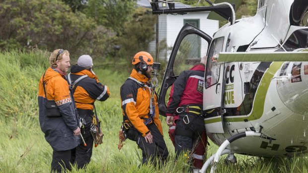 Rescue crew board a helicopter to head to the Fox Glacier valley where a helicopter crashed.