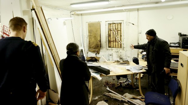 Ismail Zengin (right) chairman of the Turkish association shows the damaged office.