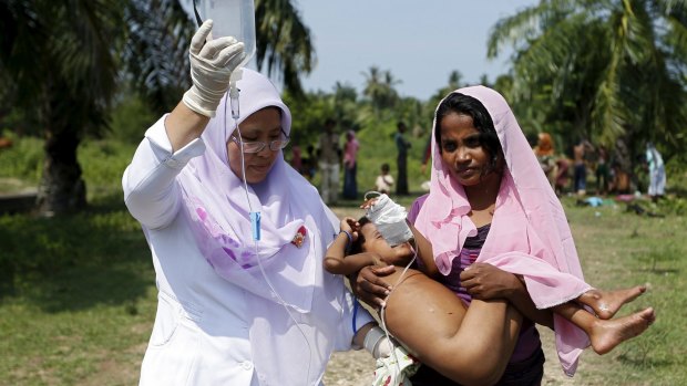 An Indonesian paramedic assists a recently-arrived Rohingya migrant mother on Thursday.