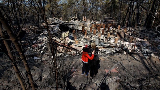 Amy Hubbard (left) with her mother, Catherine and the ruins of their home in Buena Vista Road, Winmalee, which was destroyed in bushfire in the Blue Mountains on October 18, 2013.