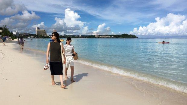 Tourists walk the beach in Tumon, Guam after North Korea's threat this week.