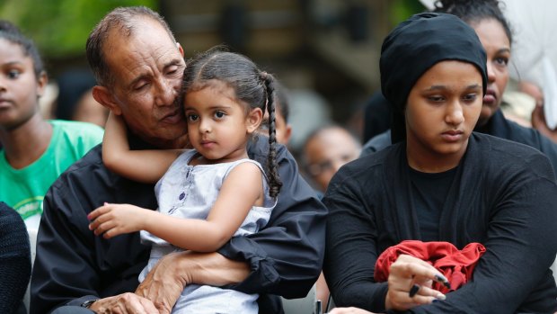 Mahmoud Hassanen Aboras with family as he listens to speakers during a vigil in honour of his daughter Nabra.