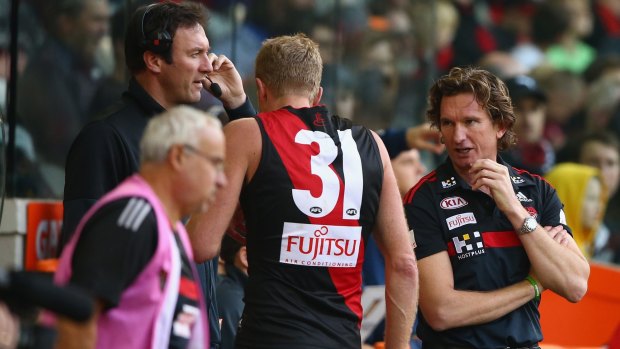 Bombers coach James Hird has a word with Dustin Fletcher on the sidelines.