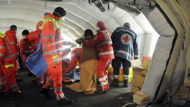 Medics help migrants in a tent after they arrived at Gallipoli harbour.
