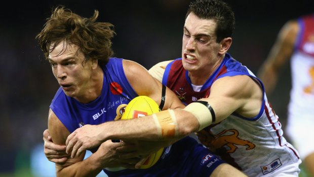 Gotcha: Liam Picken of the Bulldogs is locked up by Darcy Gardiner of the Lions.