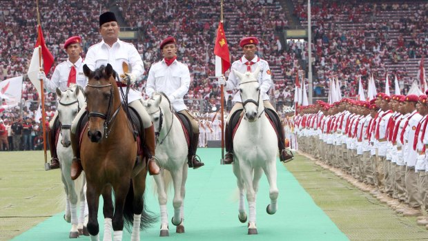 Prabowo Subianto, head of the Greater Indonesia Movement (Gerindra), rides a horse as he inspects party members during a campaign rally in Jakarta in 2014.