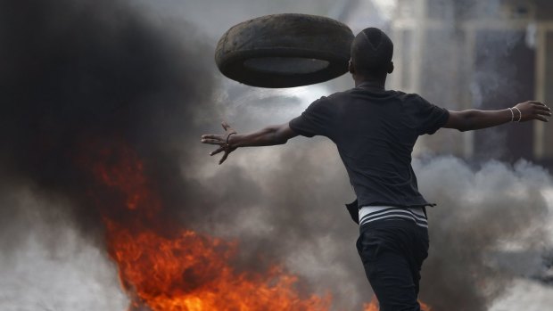 A protester hurls a tire on Tuesday at a protest against Burundi President Pierre Nkurunziza's bid for a third term.