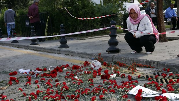 People gather at the site of the two explosions in Ankara, Turkey, to lay flowers for the victims on October 13.
