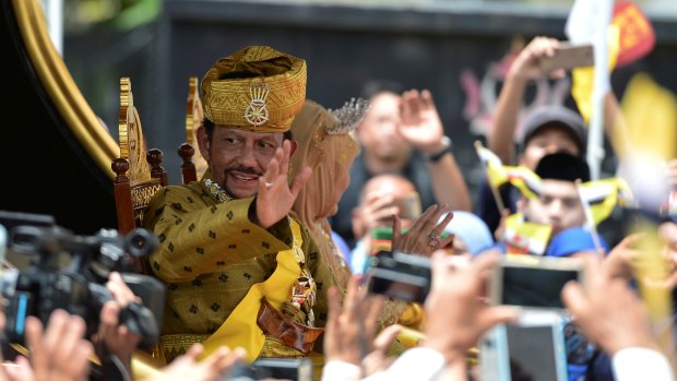 Brunei's Sultan Hassanal Bolkiah waves to people in a procession to mark his golden jubilee of his accession to the throne on Thursday.
