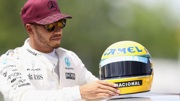 Chasing legends: Lewis Hamilton with a commemorative helmet of F1 legend Ayrton Senna after matching his record 65 pole positions.