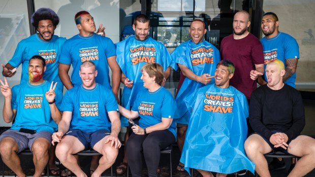 Members of the ACT Brumbies share a laugh with the Leukaemia Foundation's Belinda Barnier after getting their heads shaved and coloured for the World's Greatest Shave.