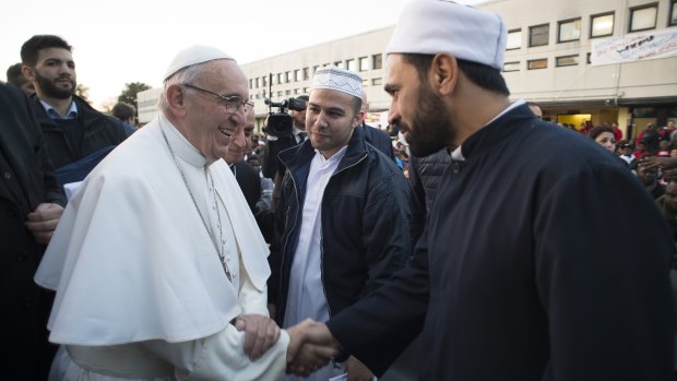 Pope Francis shakes hands with Muslims during his visit to a refugee centre near Rome on Thursday.