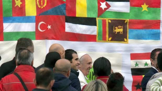 Pope Francis, centre, arrives to celebrate the Coena Domini mass and foot-washing ceremony at the Castelnuovo di Porto refugee centre, some 30 kilometres from Rome, on Thursday.