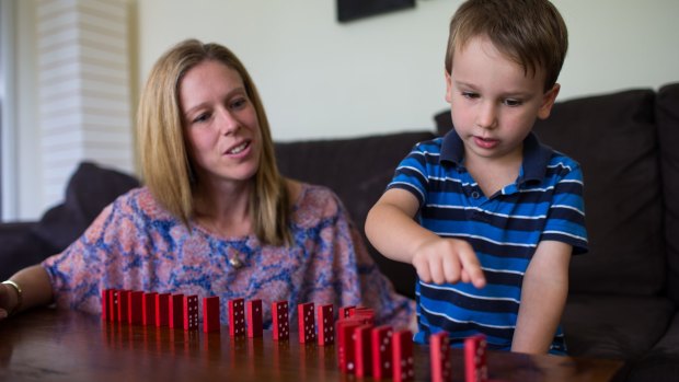 Rebecca O'Neil with son Connor , 5, counting dominos and learning to solve problems with building blocks.