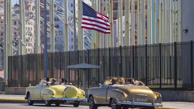 New ties: Tourists drive past the new US embassy in Havana.
