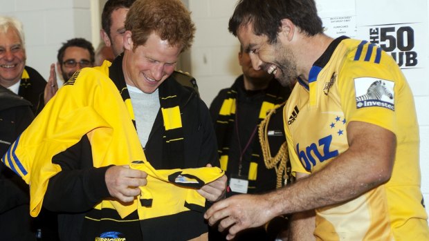 Hurricanes captain Conrad Smith presents Prince Harry with a personalised onesie for his brother Prince William's daughter, Princess Charlotte.