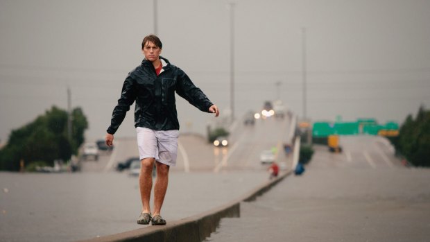 Jett Bush walks towards home after trying to visit a friend on the other side of floodwaters in Houston's Meyerland area.