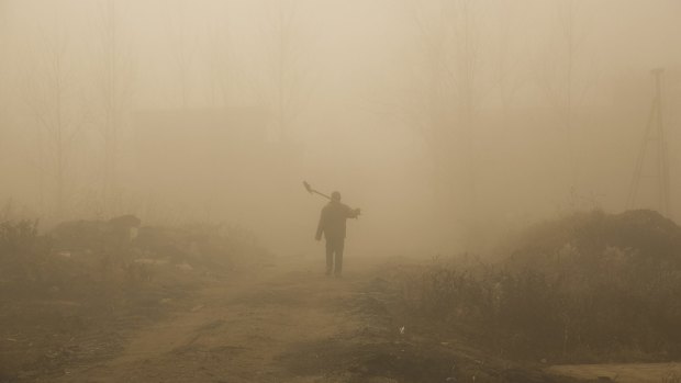 A farmer walks in heavy smog on December 31 in Beijing, China.