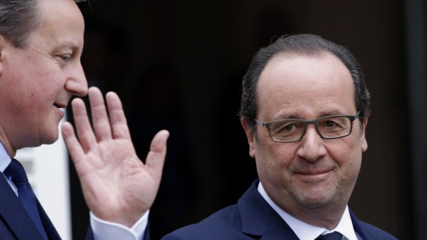 French President Francois Hollande, right, waves as he poses with British Prime Minister David Cameron in Amien, France, on Thursday. 