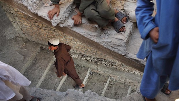 Boys roam through an incomplete house in Amanullah Khan. Islamic State fighters have seized control in several districts of Nangahar province and are fighting Taliban elements for more. 