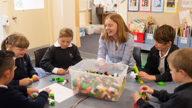 Sum total of effort and passion:  Lumen Christi Catholic Primary School teacher Cassandra Lowry delights in maths. Here she is helping her year 3 extension program students. 