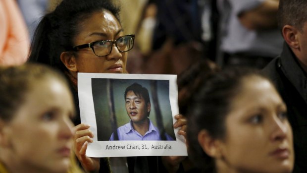 A supporter of Andrew Chan holds a picture of him at a vigil in Sydney on Tuesday.