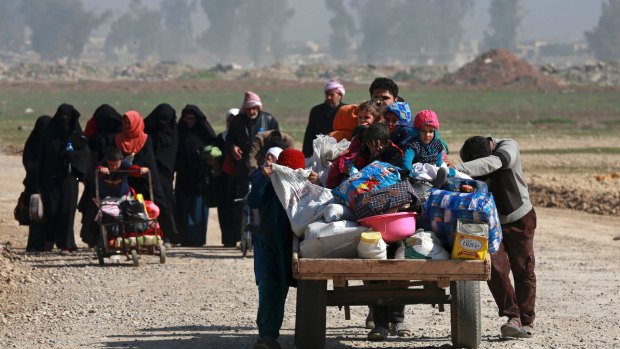 Iraqi civilians fleeing their homes due to fighting between government forces and IS on the western side of Mosul in March.