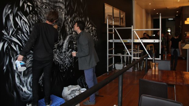 Sonlife International founder Josh Bond inspects the work of Perth street artist Steve Browne at new venture Halo Espresso. Photo: Emma Young