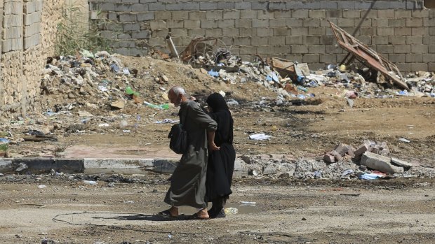 A couple flees their home during fights between Iraqi security forces and Islamic State in Hit, Iraq, on Wednesday. 