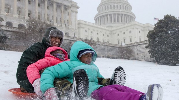 Bashon Mann and his children sled down a hill on Capitol Hill in Washington as snow falls. With a major blizzard threatens to dump over 90 centimetres of snow on Washingon, DC.